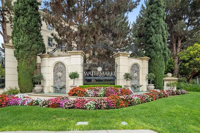 a front view of a house with a garden and tree