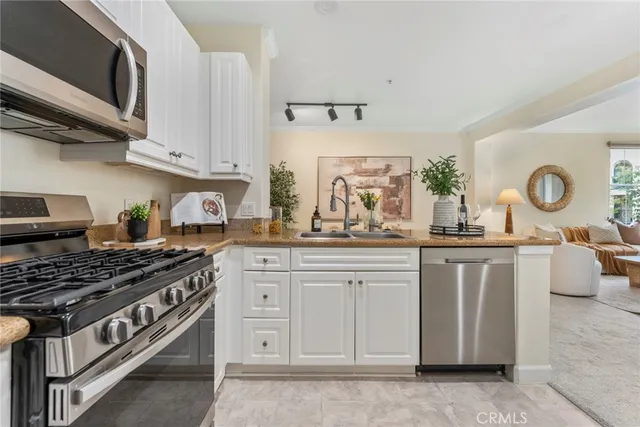 a kitchen with granite countertop a sink a stove and cabinets