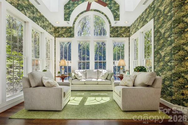 a bedroom with a bed couches and wooden floor
