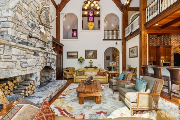 a living room with furniture a fireplace and a floor to ceiling window
