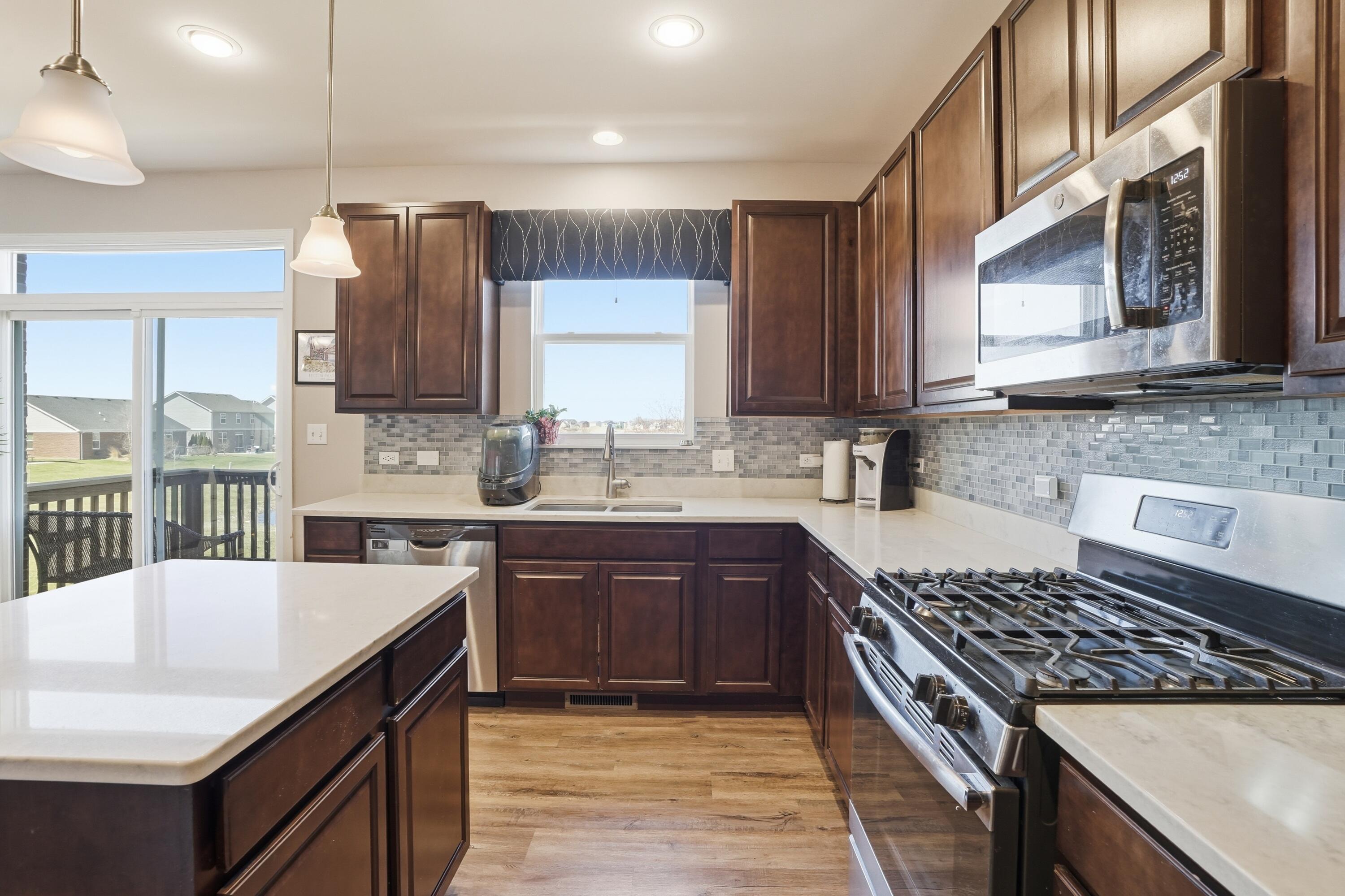 10322 Adler Cove St. John, IN 46373 - Photo 9 of 26 a kitchen with stainless steel appliances granite countertop a sink stove and refrigerator