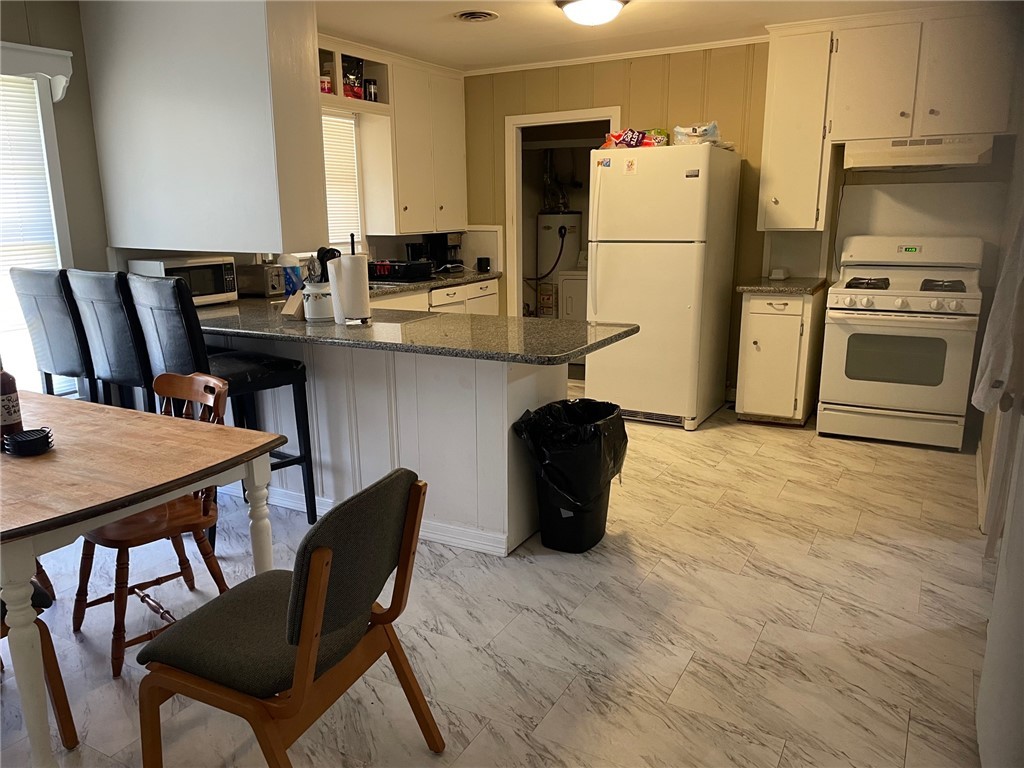 4400 Oaklawn Street Bryan, TX 77801 - Photo 6 of 7 a kitchen with a refrigerator a stove a sink and chairs