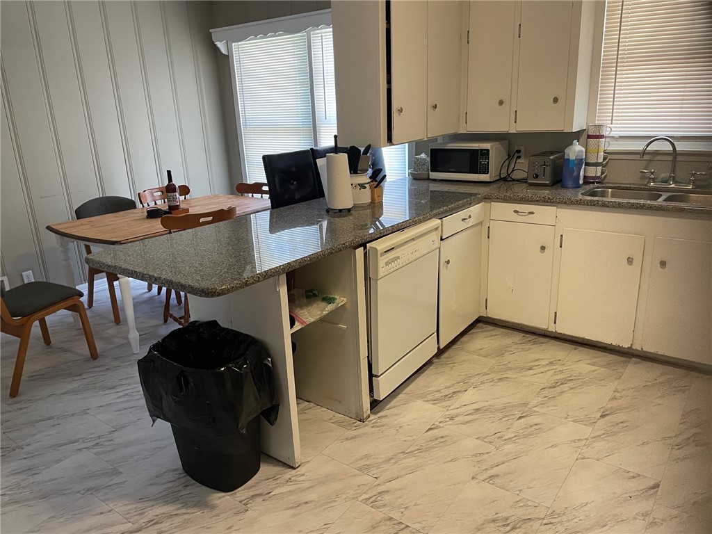 4400 Oaklawn Street Bryan, TX 77801 - Photo 7 of 7 a kitchen with a sink cabinets and wooden floor