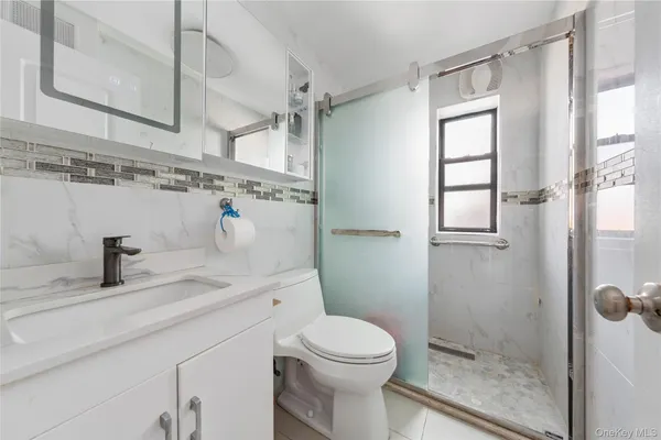 a bathroom with a sink a toilet and shower