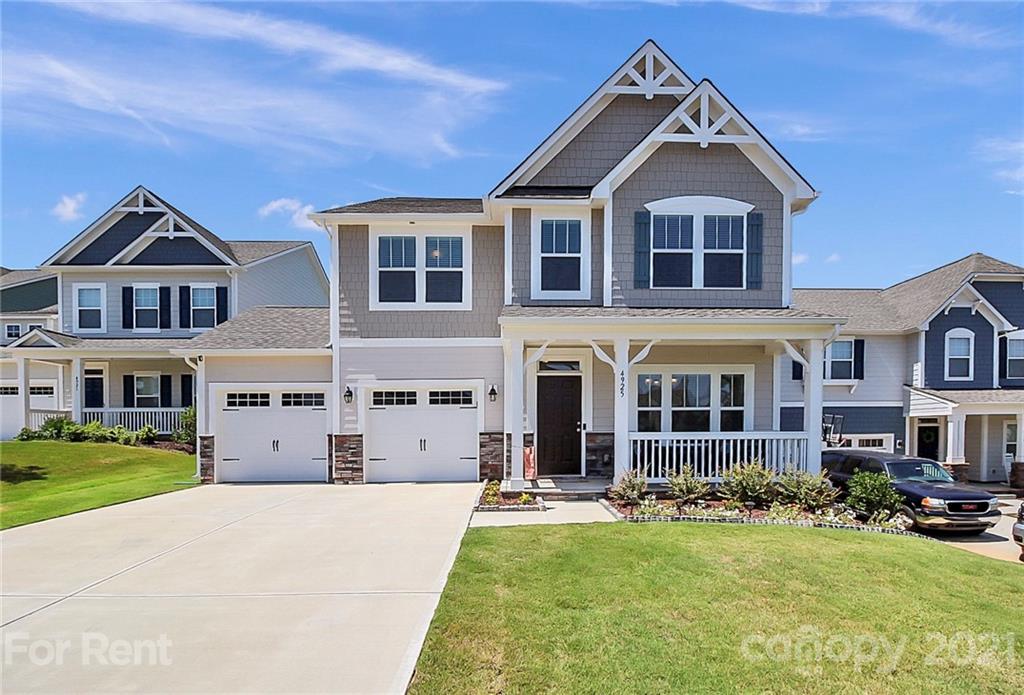 a front view of a house with yard and green space