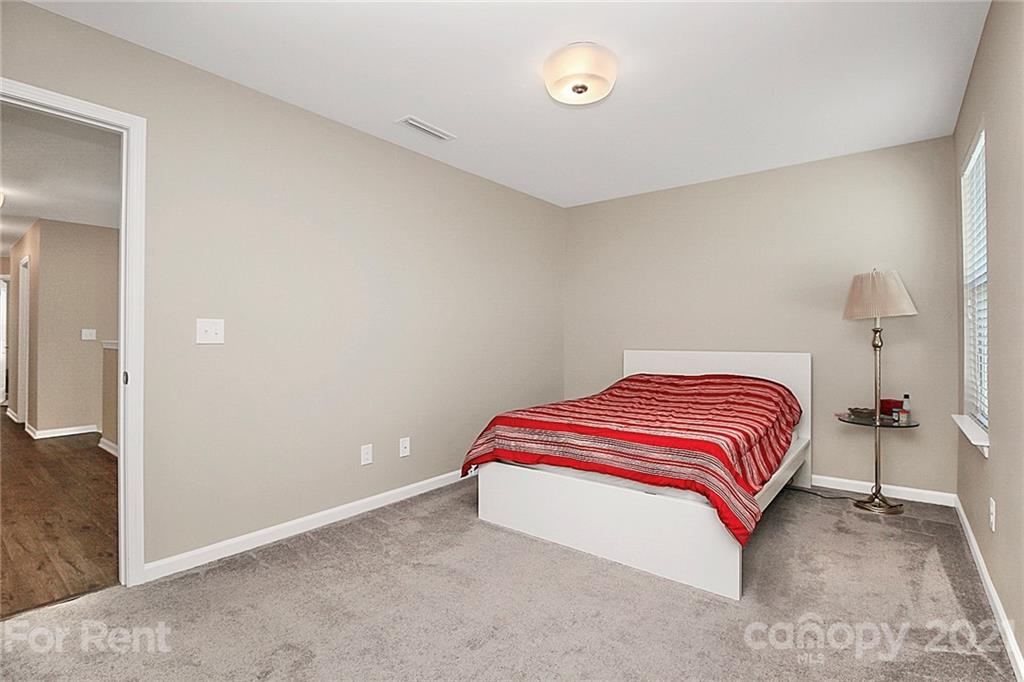 4925 Grace View Drive Pineville, NC 28134 - Photo 20 of 41 a bedroom with a bed and a lamp