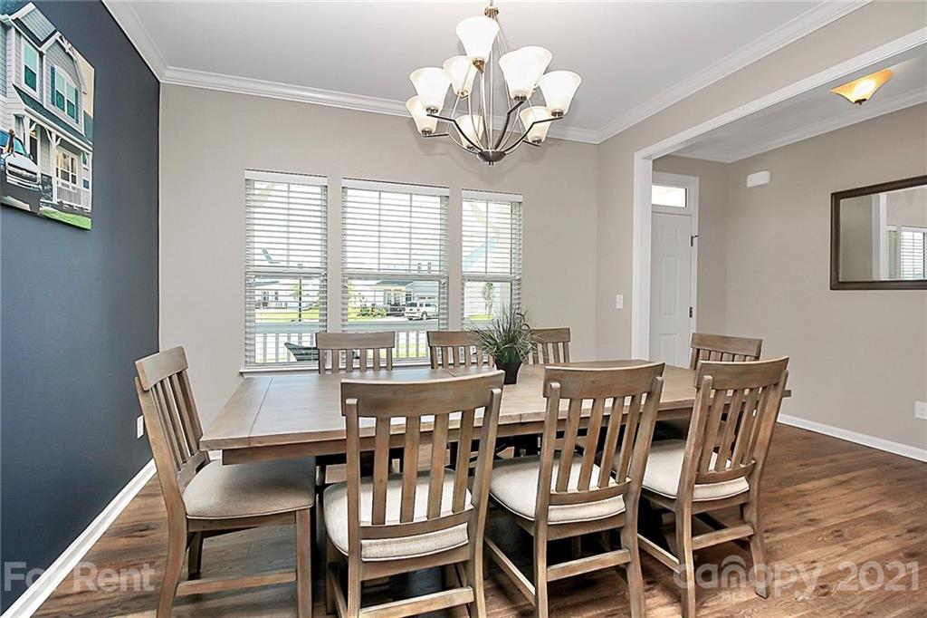 4925 Grace View Drive Pineville, NC 28134 - Photo 3 of 41 a view of a dining room with furniture a chandelier and wooden floor