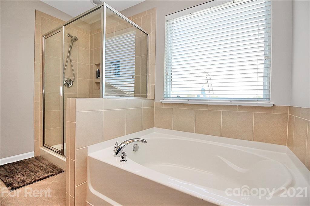 4925 Grace View Drive Pineville, NC 28134 - Photo 31 of 41 a bathroom with a tub a sink and a window