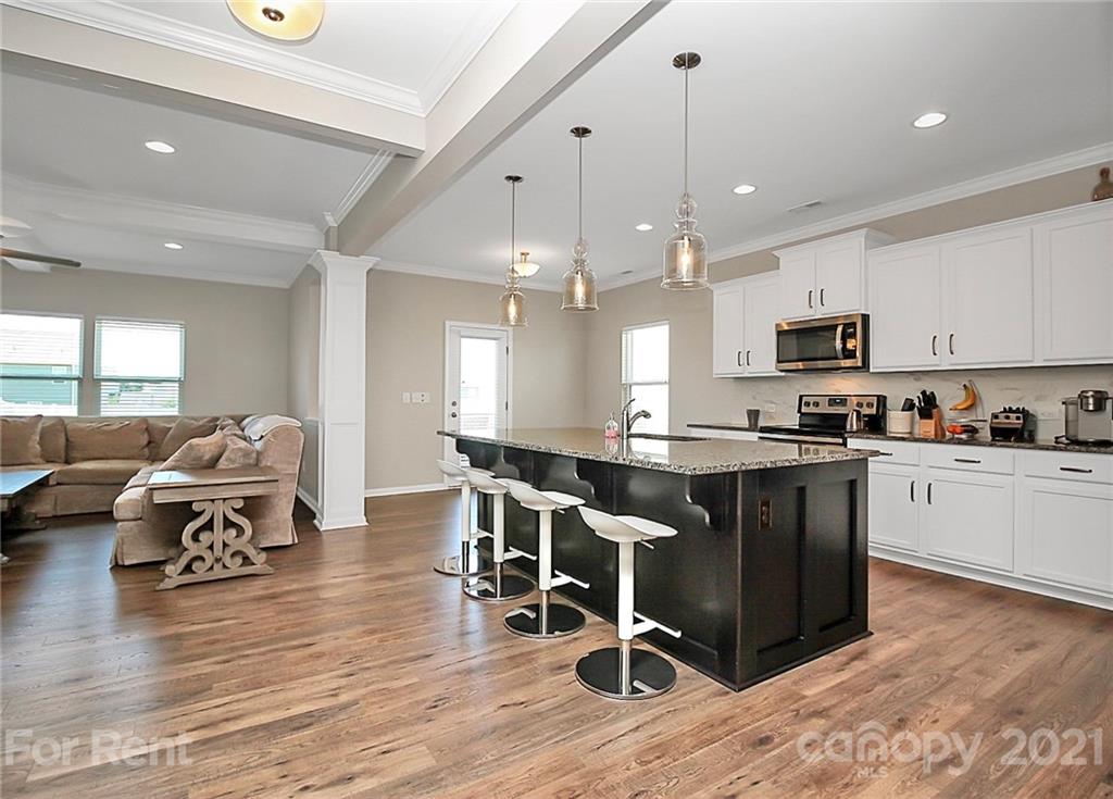 4925 Grace View Drive Pineville, NC 28134 - Photo 6 of 41 a kitchen with stainless steel appliances granite countertop wooden floors a stove and a refrigerator
