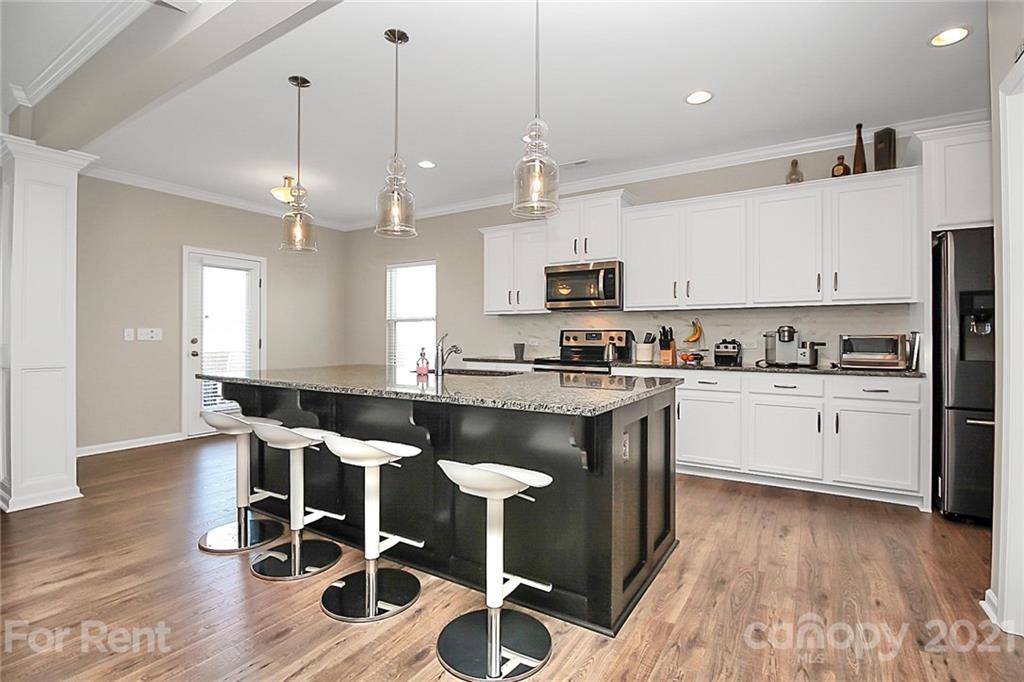 4925 Grace View Drive Pineville, NC 28134 - Photo 7 of 41 a kitchen with granite countertop a counter space a sink stainless steel appliances and cabinets