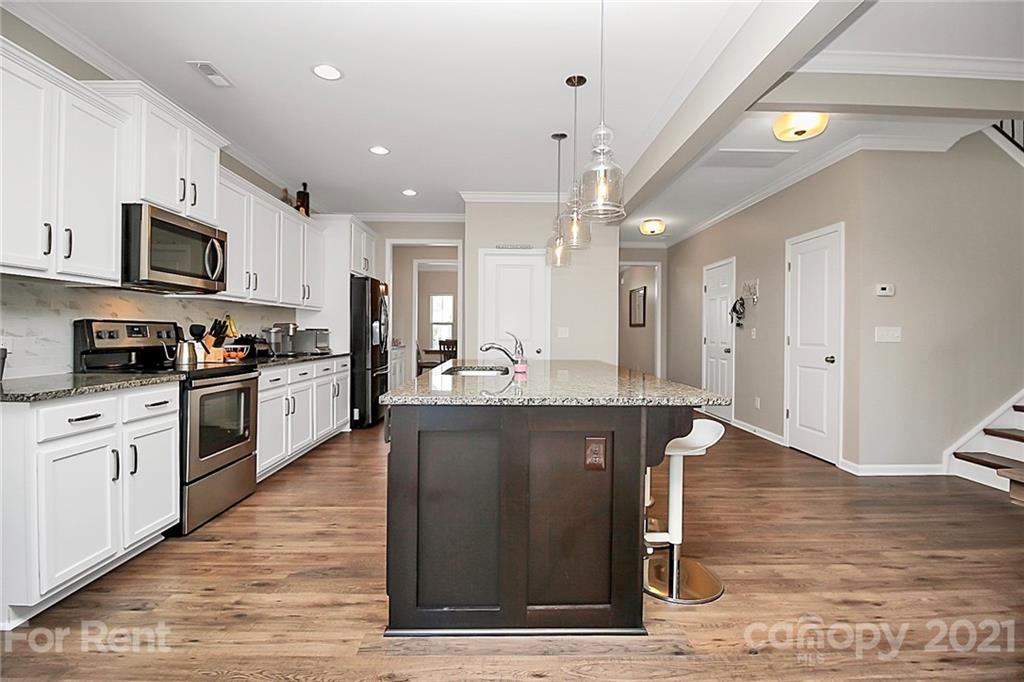 4925 Grace View Drive Pineville, NC 28134 - Photo 8 of 41 a kitchen with stainless steel appliances granite countertop a refrigerator a sink dishwasher a stove and white cabinets with wooden floor