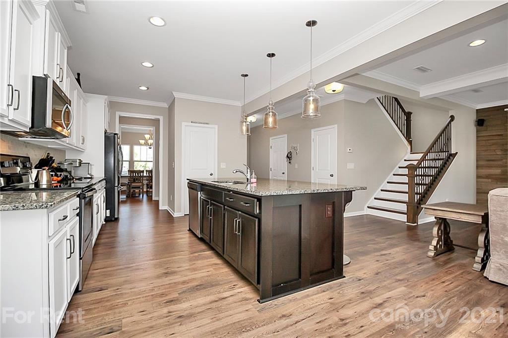 4925 Grace View Drive Pineville, NC 28134 - Photo 9 of 41 a large kitchen with stainless steel appliances a stove and wooden floor