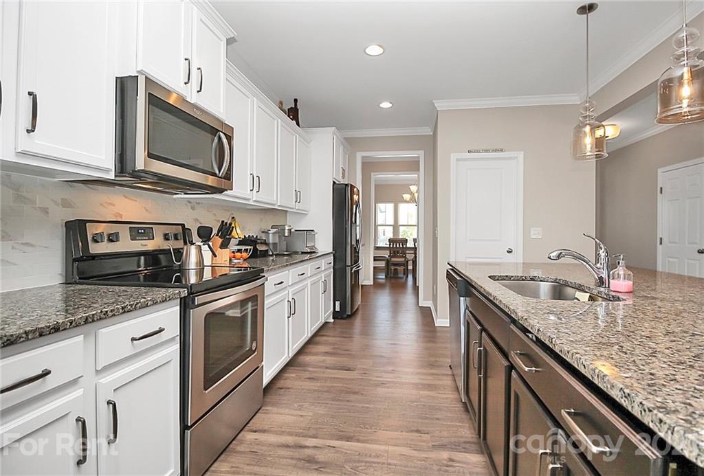4925 Grace View Drive Pineville, NC 28134 - Photo 10 of 41 a large kitchen with stainless steel appliances granite countertop a sink stove and refrigerator