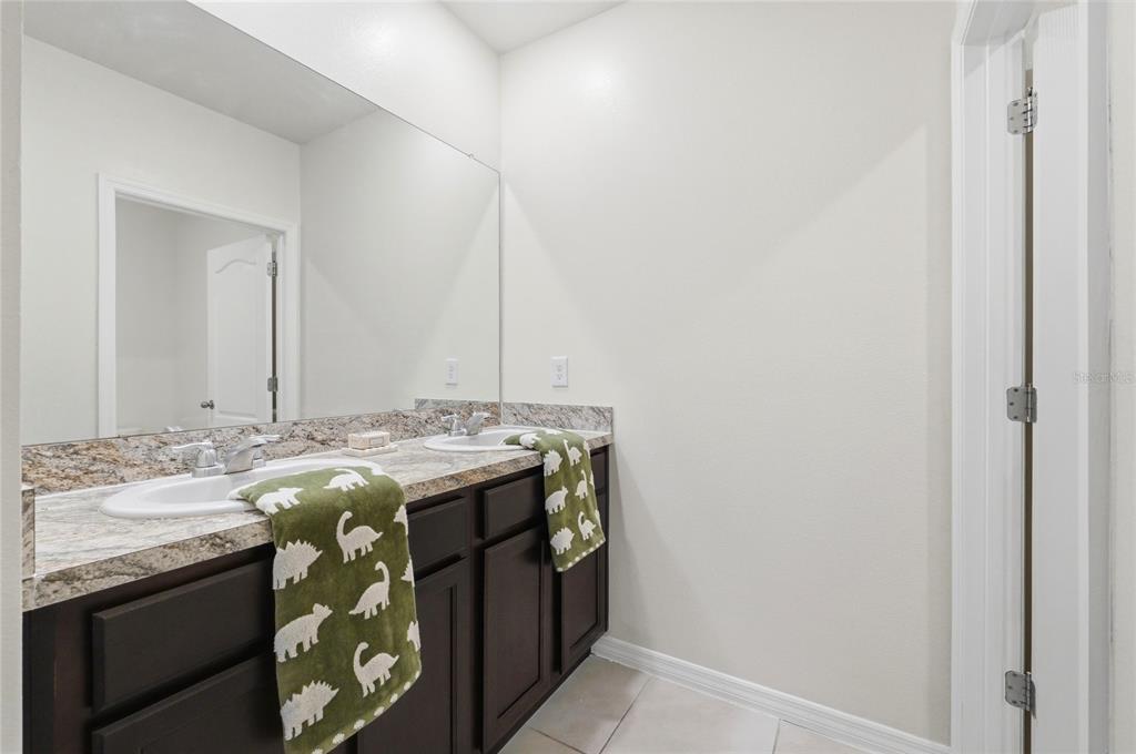 416 Corso Loop Winter Haven, FL 33884 - Photo 35 of 73 a bathroom with a granite countertop sink and a mirror