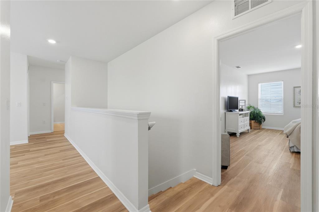 416 Corso Loop Winter Haven, FL 33884 - Photo 52 of 73 a view of a hallway with wooden floor and a living room