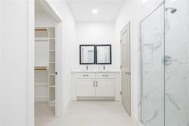 a bathroom with a shower a sink and a mirror