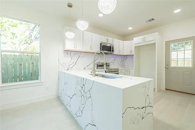 a kitchen with white cabinets and appliances