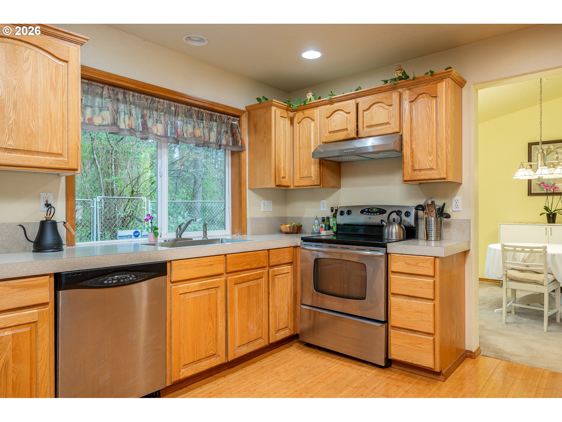 14300 Southeast Center Street Portland, OR 97236 - Photo 12 of 48 a kitchen with stainless steel appliances granite countertop a stove a sink and white cabinets