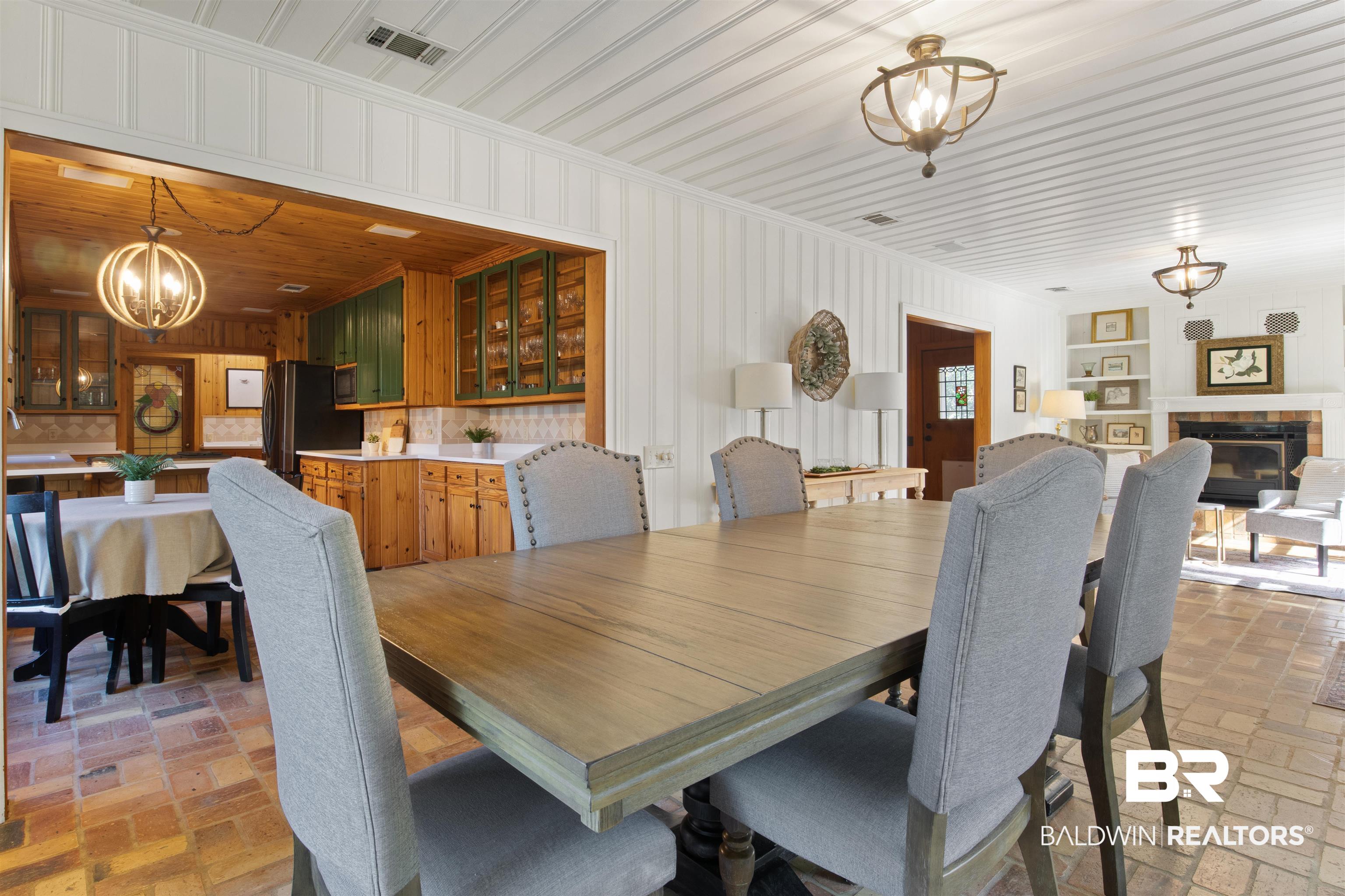 15100 Vasko Road Silverhill, AL 36576 - Photo 15 of 51 Dining area with a tiled fireplace, wood ceiling, ornamental molding, and a chandelier