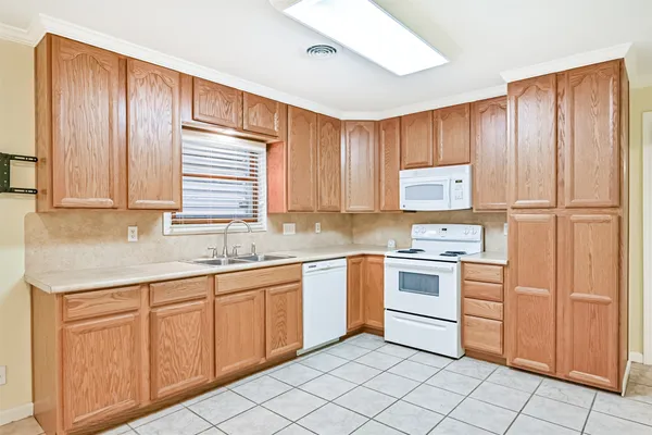 a kitchen with white cabinets stainless steel appliances and sink