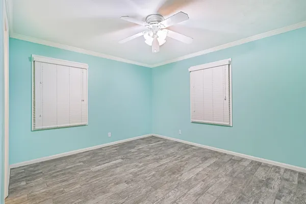 an empty room with a window and a chandelier fan