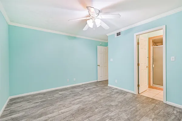 a view of an empty room with window and a ceiling fan