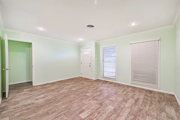 a view of an empty room with wooden floor