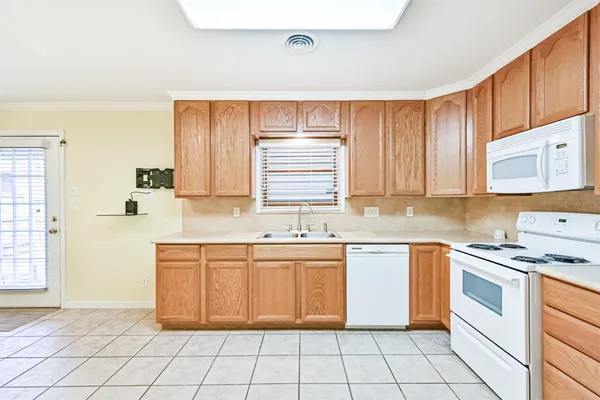 a kitchen with a sink window and cabinets
