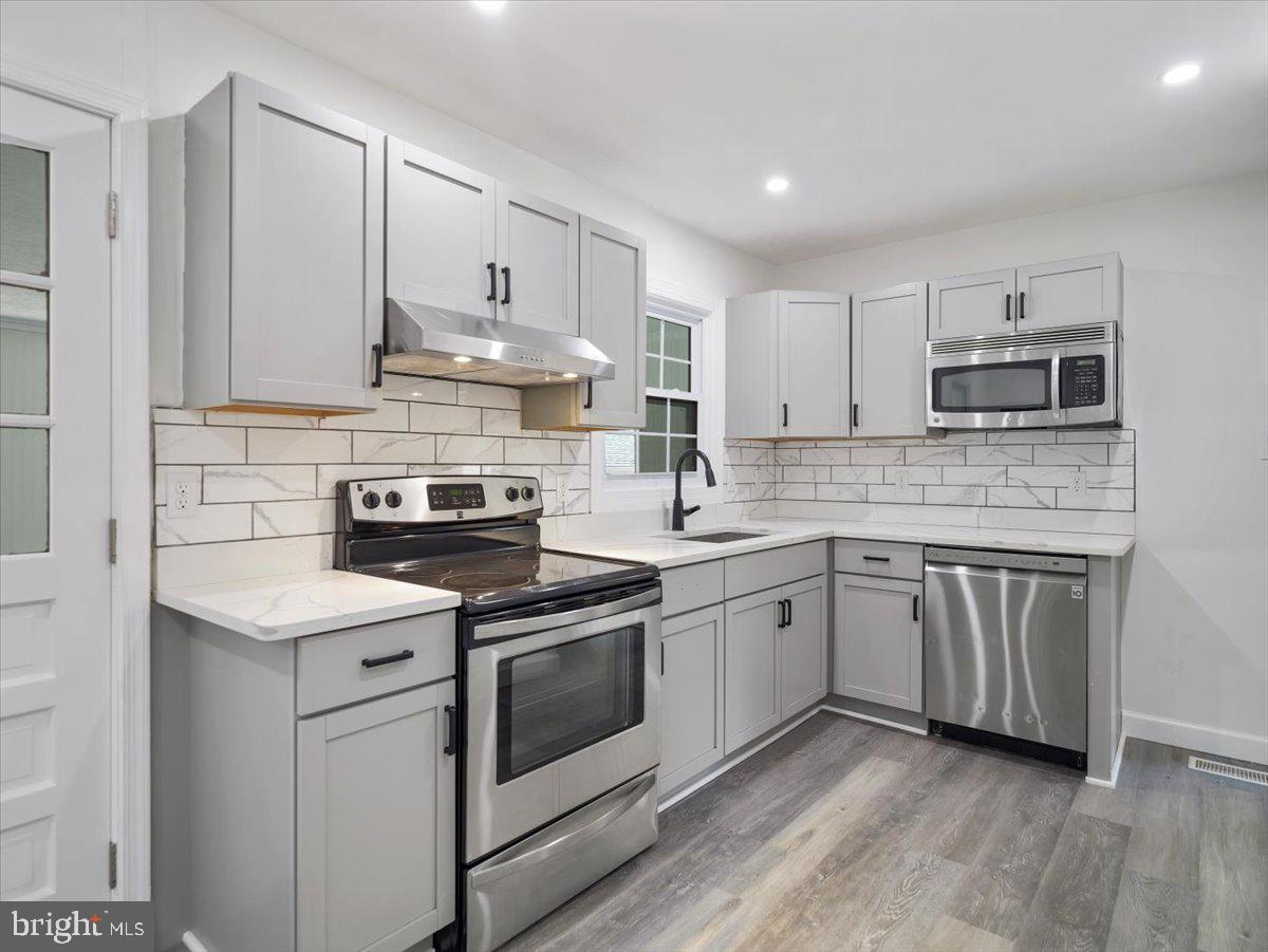8704 Orndorff Road Thurmont, MD 21788 - Photo 9 of 43 a kitchen with cabinets stainless steel appliances a sink and wooden floor