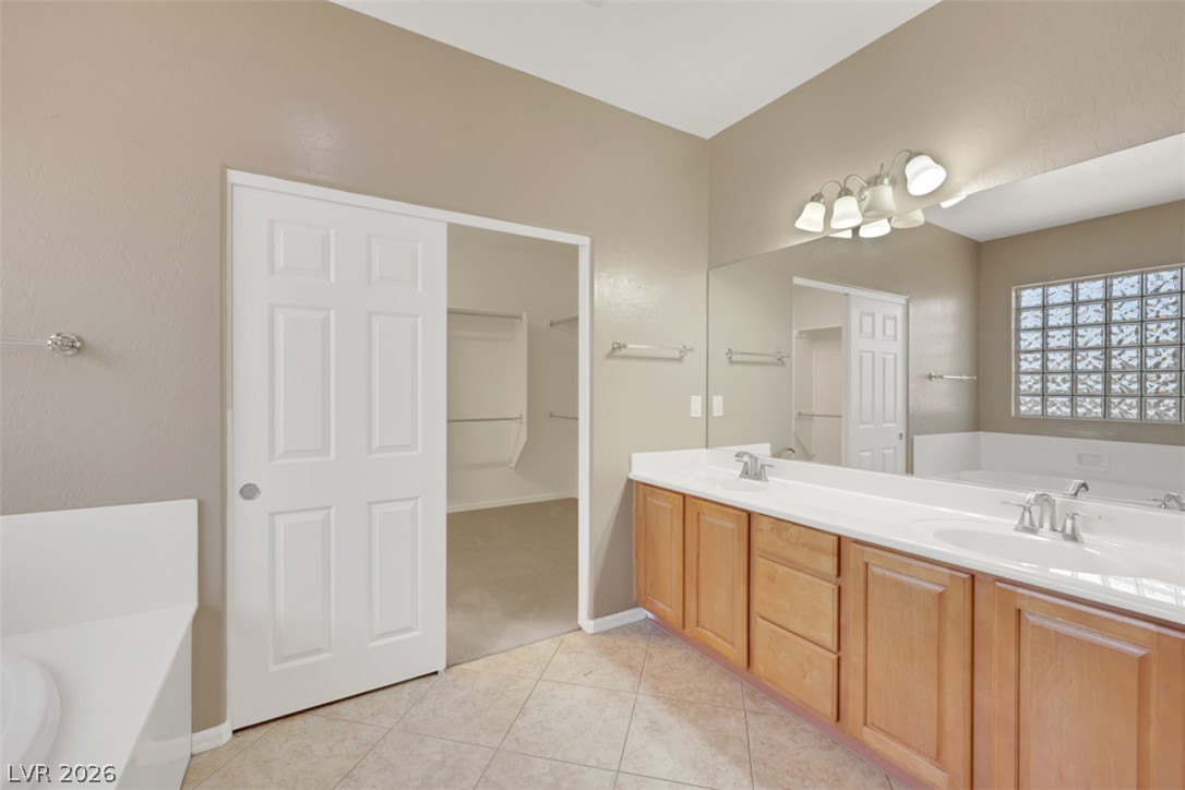 2501 Bechamel Place Henderson, NV 89044 - Photo 38 of 50 Double vanities and a deep soaking tub create a personal spa experience in this well-appointed bathroom.