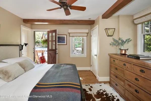 a view of backyard with a large window and wooden floor