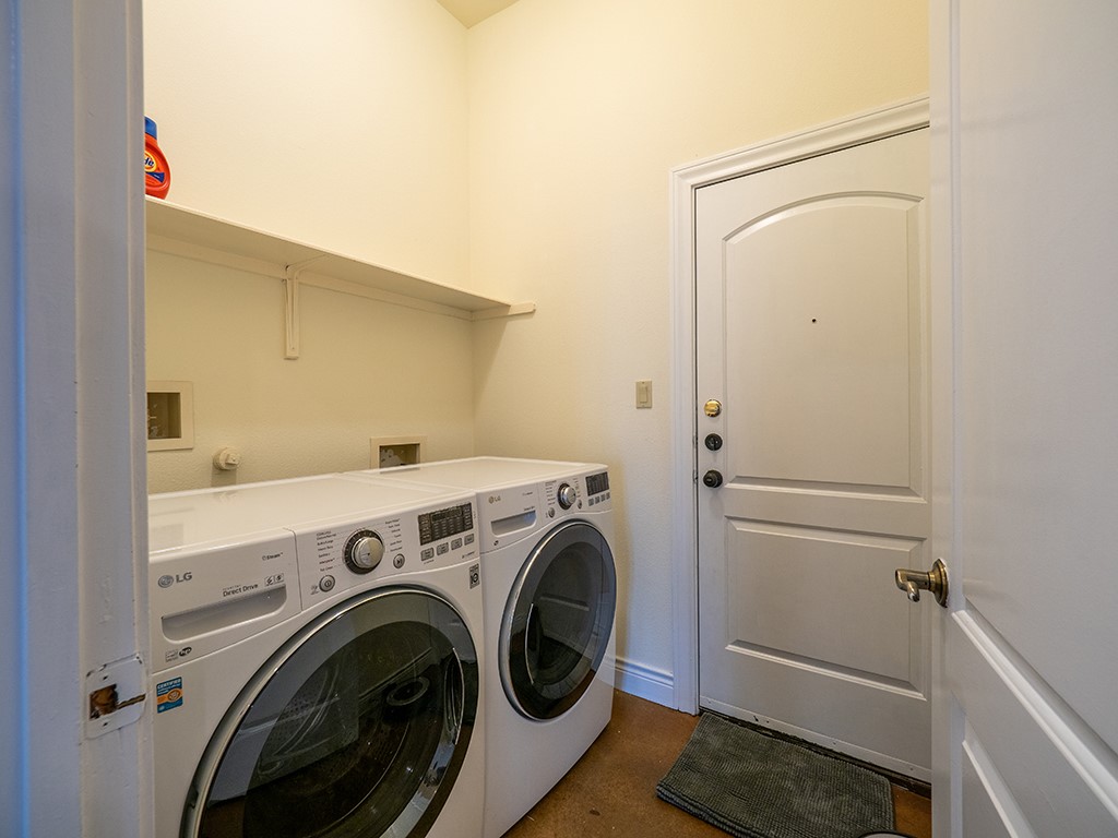 3609 Clawson Road, Unit B Austin, TX 78704 - Photo 27 of 28 Dedicated laundry area featuring a built-in shelf, neutral wall tones, and a solid entry door with a decorative arch panel