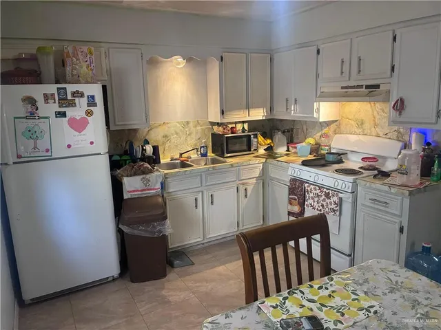 a kitchen with a sink a stove a refrigerator and cabinets