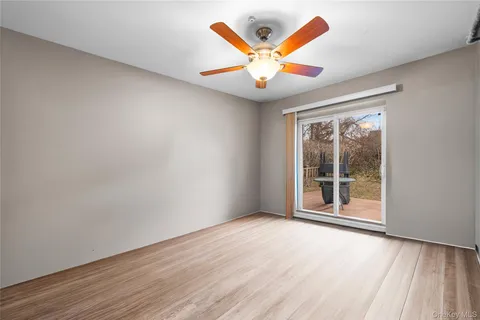 an empty room with window and ceiling fan