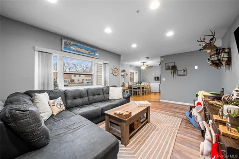 a living room with furniture a flat screen tv and a window