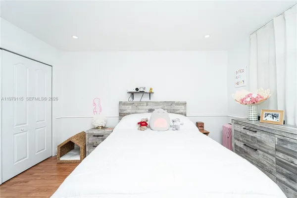 a bedroom with a bed and wooden floor