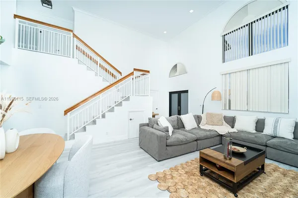 a living room with furniture wooden floor and a large window