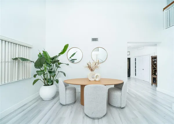a dining room with furniture potted plants and wooden floor