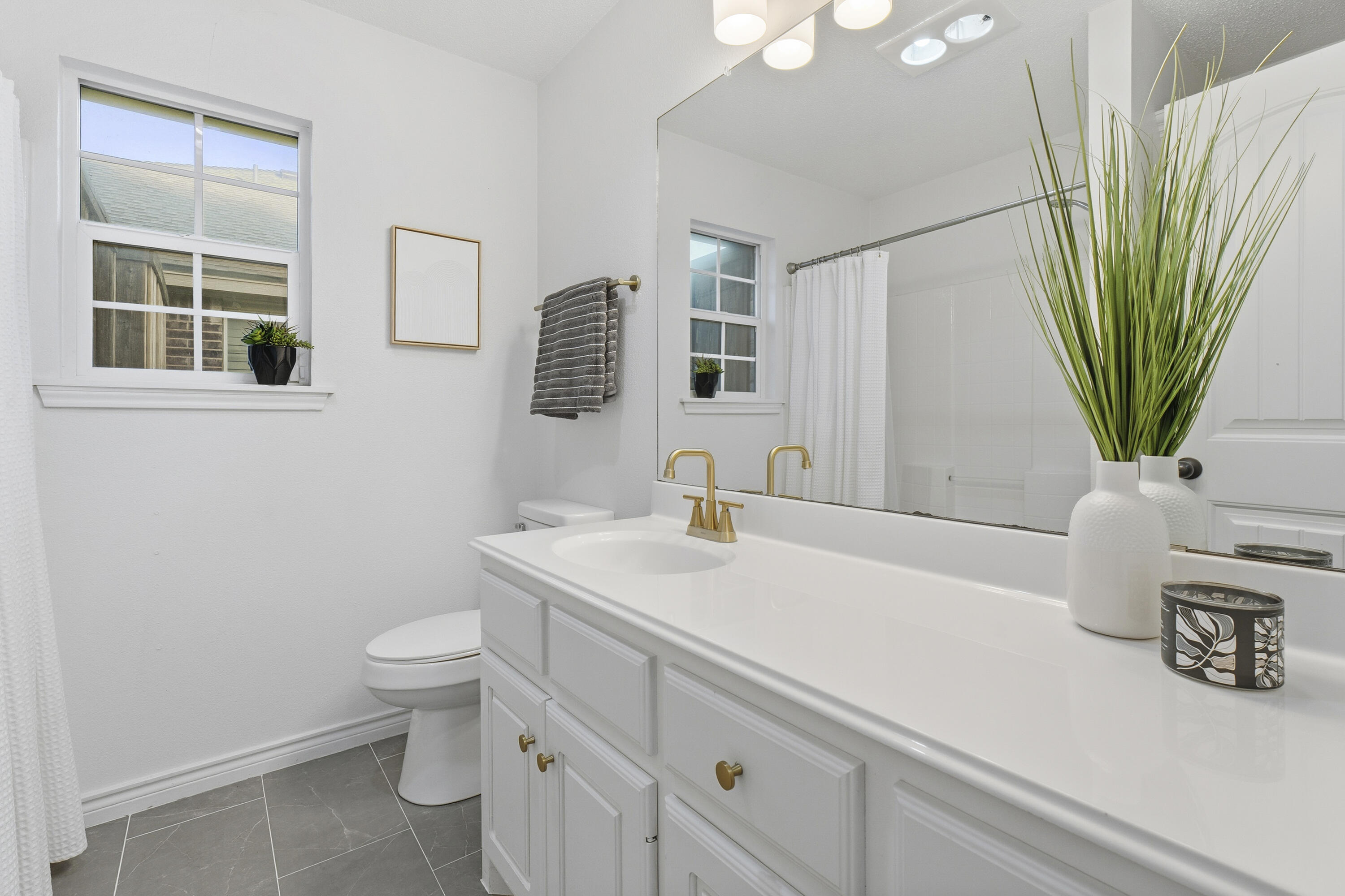 5830 101st Street Lubbock, TX 79424 - Photo 19 of 26 a bathroom with a sink a toilet and a mirror