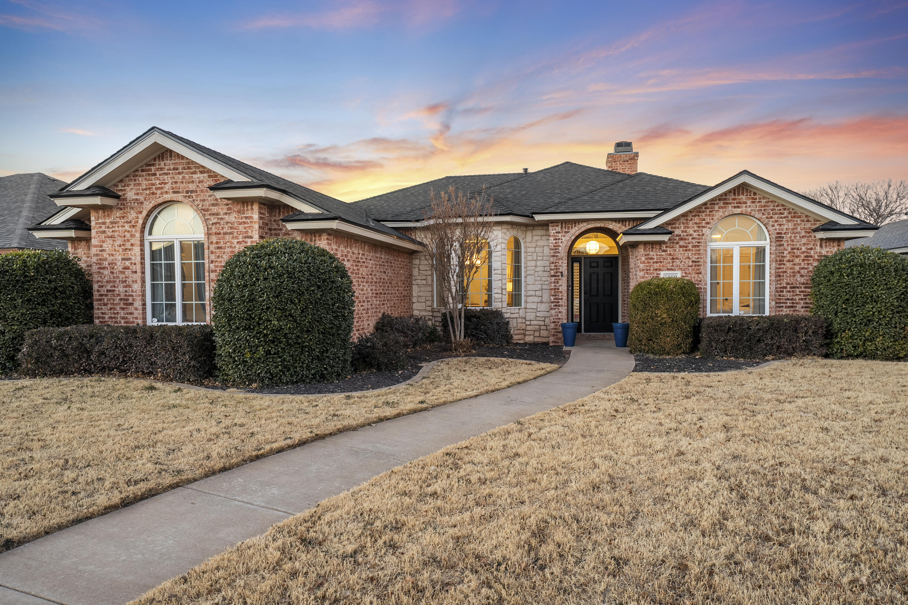 5830 101st Street Lubbock, TX 79424 - Photo 2 of 26 a front view of a house with a yard and garage