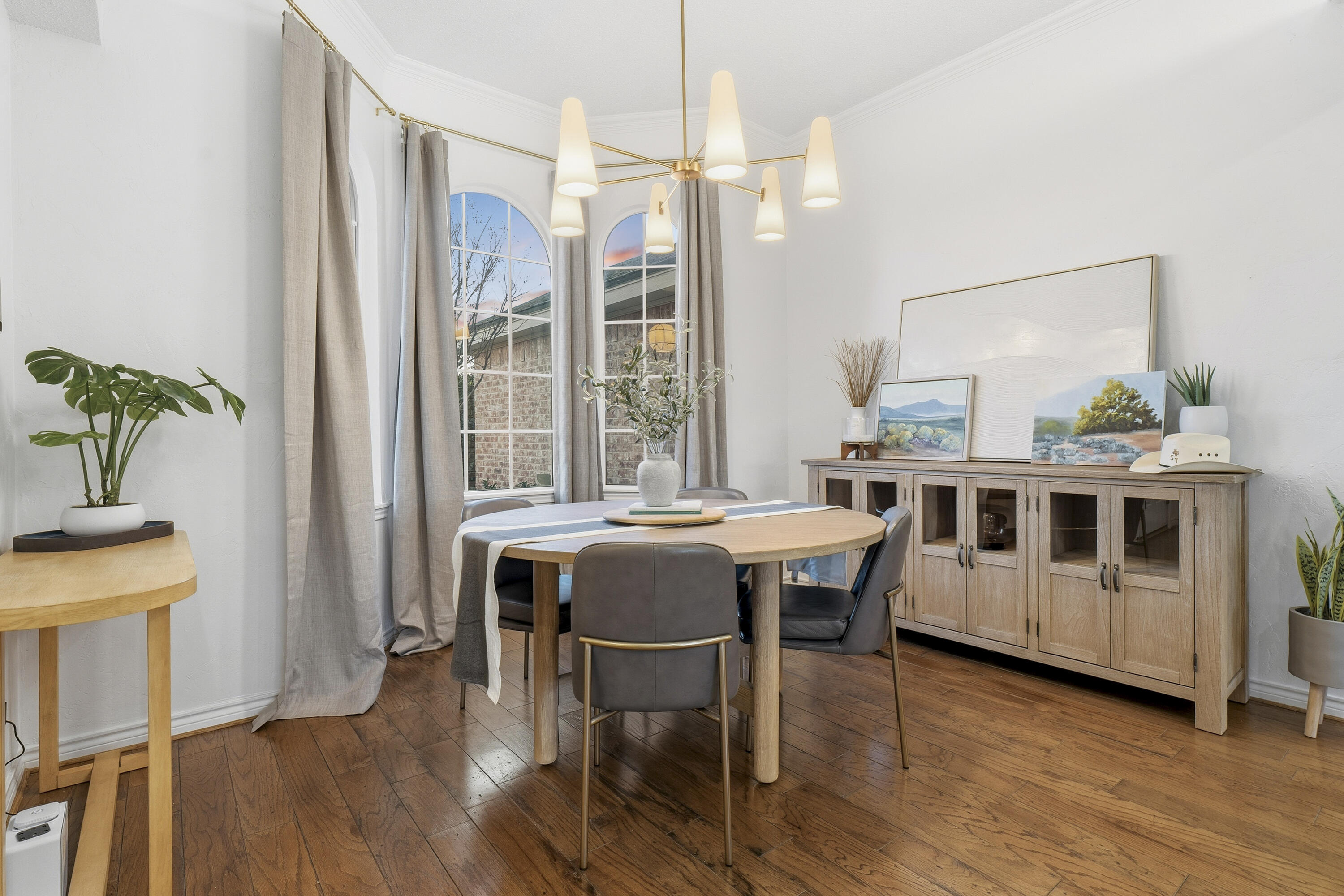 5830 101st Street Lubbock, TX 79424 - Photo 4 of 26 a dining room with furniture wooden floor a potted plant and a chandelier