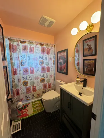 a bathroom with a sink mirror and a toilet