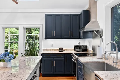 a kitchen with a sink a stove and a wooden cabinets