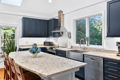 a kitchen with granite countertop a sink stove and refrigerator