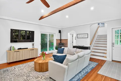a living room with furniture wooden floor and a flat screen tv