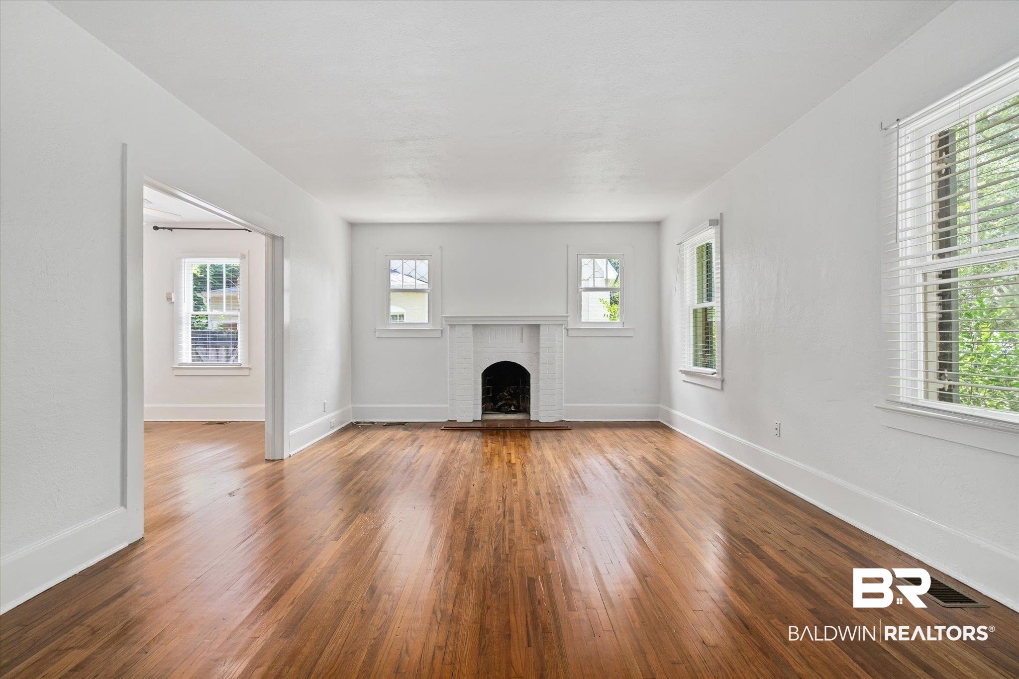 1159 Palmetto Street Mobile, AL 36604 - Photo 5 of 21 Unfurnished living room with hardwood / wood-style floors, a brick fireplace, and plenty of natural light