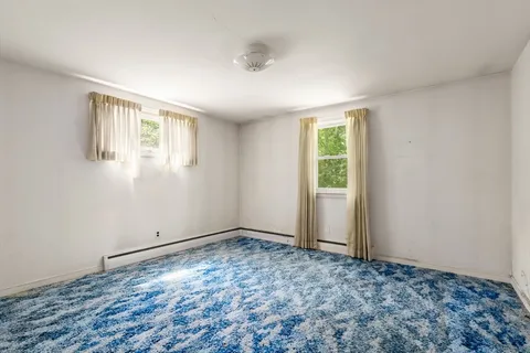 a view of an empty room with window and closet area
