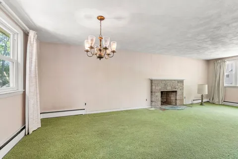 a view of empty room with a fireplace and window
