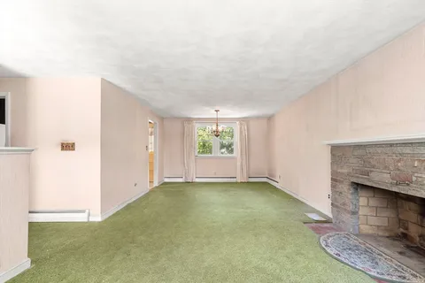 a view of an empty room with a fireplace and a window