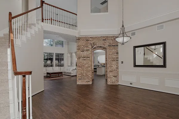a view of empty room with stairs and wooden floor